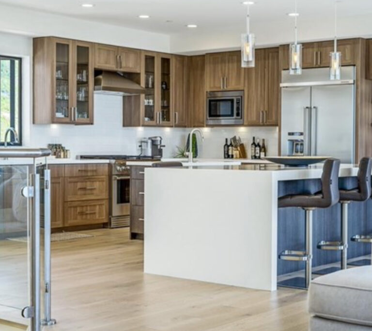 Kitchen with wood cabinets, sliver appliances and a white island.